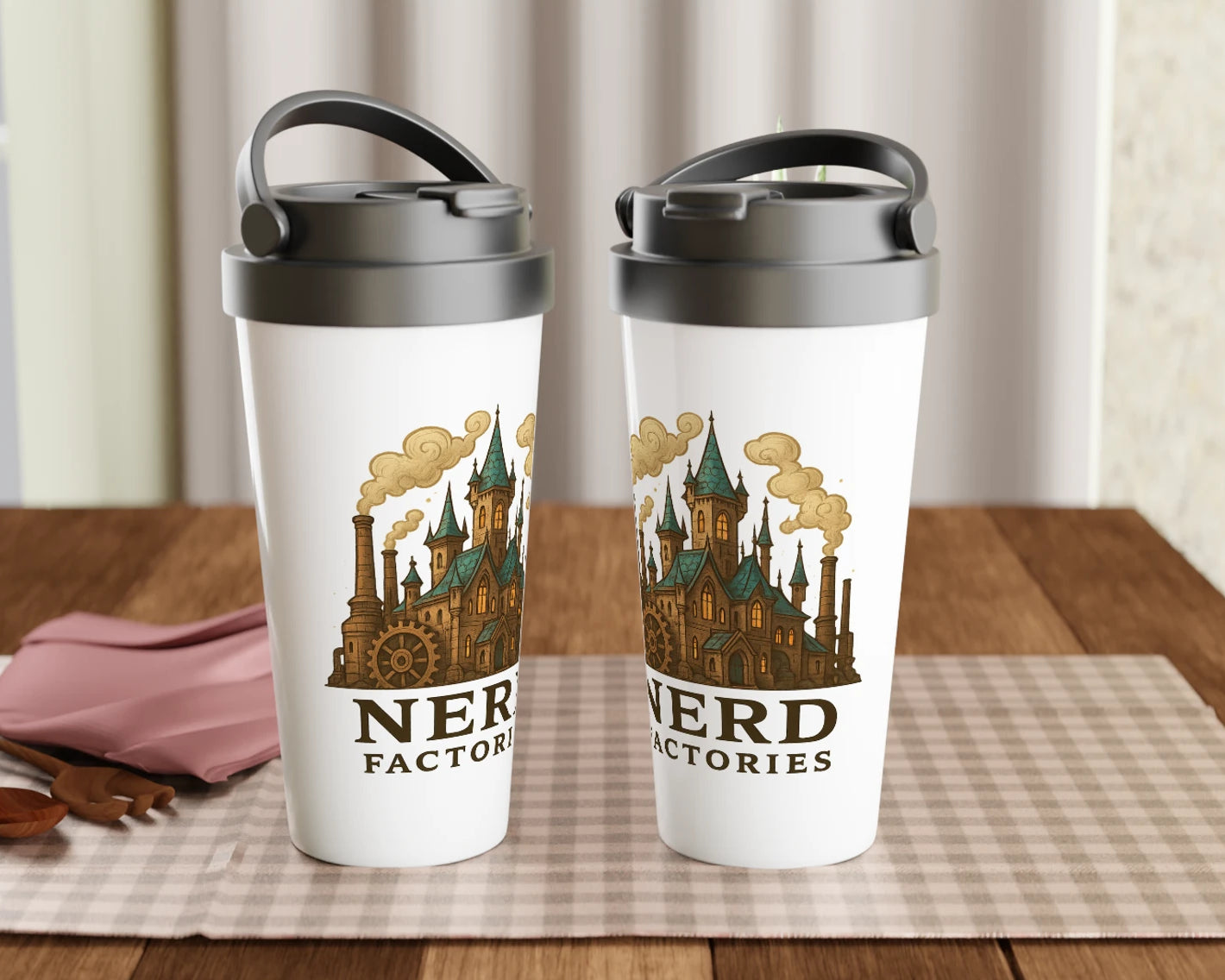 Two tumblers with a castle design and 'Nerd Factories' text on a pink checkerboard cloth