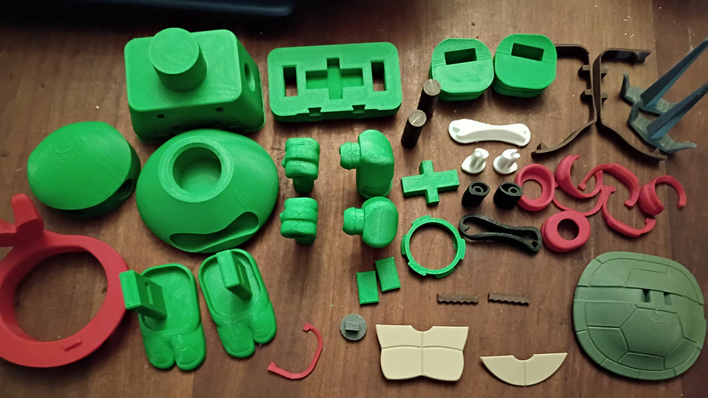 Collection of green and red plastic parts on a wooden surface