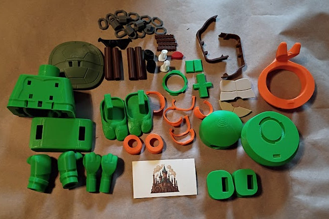 Collection of green and orange toy parts on a brown surface