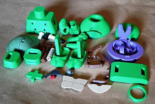 Collection of green plastic toys on brown paper