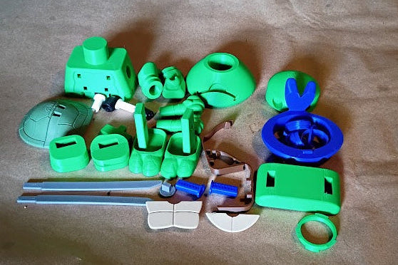 Green and blue plastic toy pieces on a brown surface