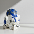 Small robot figurine on a white surface with a light gray wall in the background